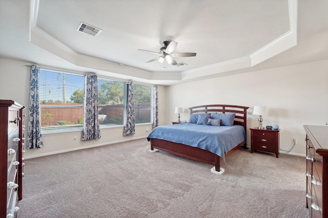 carpeted bedroom with a raised ceiling, ceiling fan, and ornamental molding