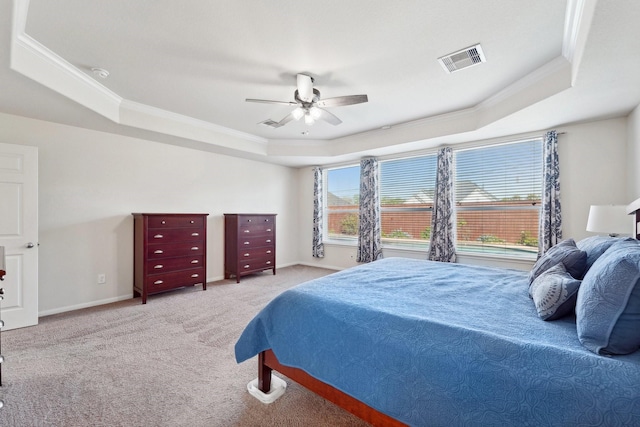 carpeted bedroom with ceiling fan, a raised ceiling, and crown molding