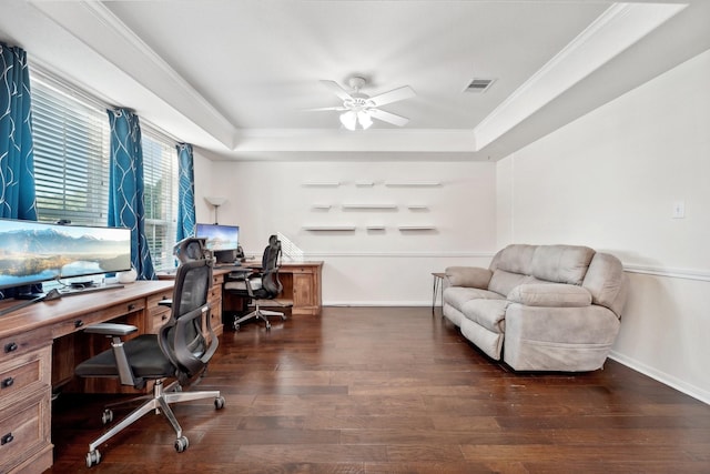 office space featuring a tray ceiling, ceiling fan, crown molding, and dark wood-type flooring