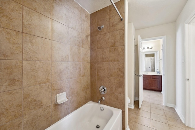 bathroom with tile patterned flooring, tiled shower / bath combo, and vanity