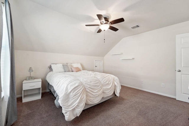 bedroom with ceiling fan, dark carpet, and vaulted ceiling