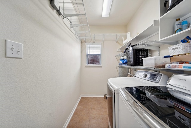 laundry area featuring washer and clothes dryer and light tile patterned floors