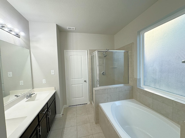 bathroom with separate shower and tub, plenty of natural light, vanity, and tile patterned flooring