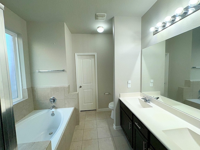 bathroom featuring tile patterned floors, vanity, toilet, and tiled tub