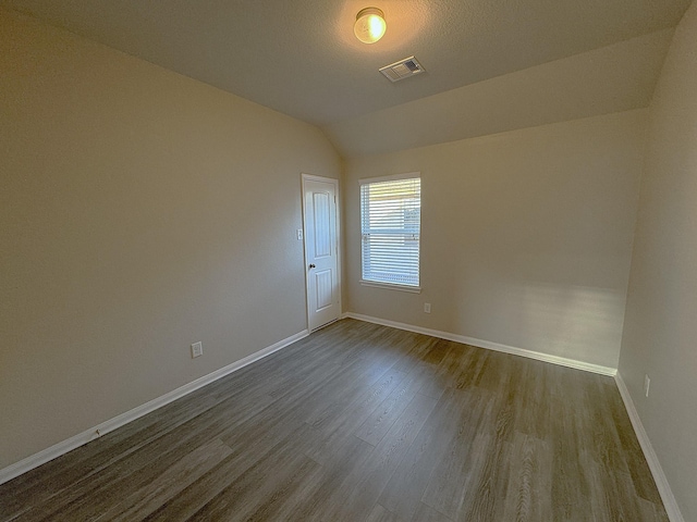 unfurnished room featuring wood-type flooring, a textured ceiling, and vaulted ceiling