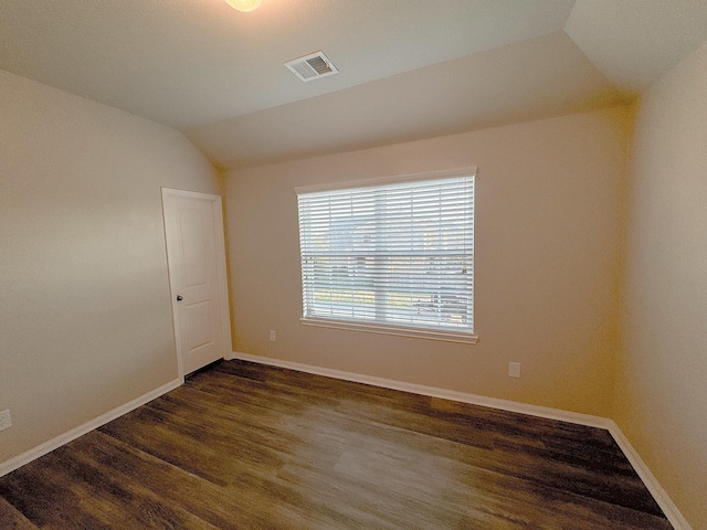 spare room with dark hardwood / wood-style floors and lofted ceiling