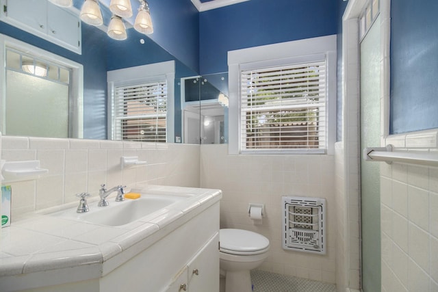 bathroom featuring heating unit, vanity, tile walls, and toilet