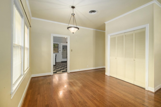 unfurnished dining area with hardwood / wood-style flooring and crown molding