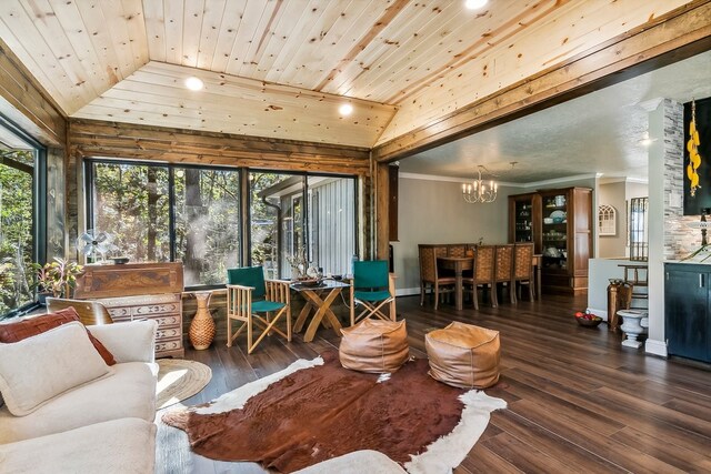 living area with a notable chandelier, vaulted ceiling, and wood finished floors