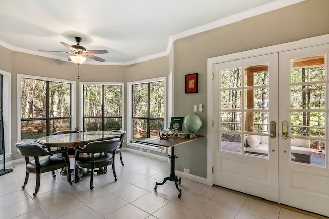 sunroom featuring baseboards, crown molding, tile patterned flooring, and french doors