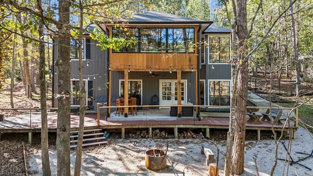 rear view of house with ceiling fan, a deck, and french doors