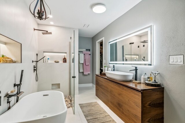 full bath with visible vents, a walk in shower, vanity, and a freestanding bath