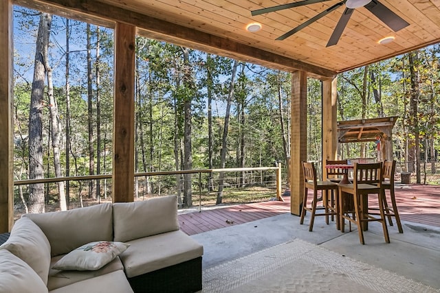 sunroom with ceiling fan and wood ceiling