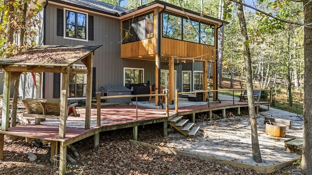 back of house featuring a sunroom and a wooden deck