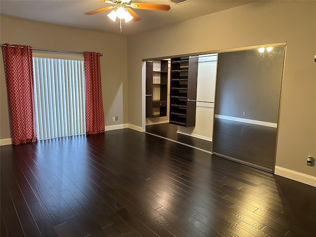 empty room with ceiling fan and dark hardwood / wood-style floors