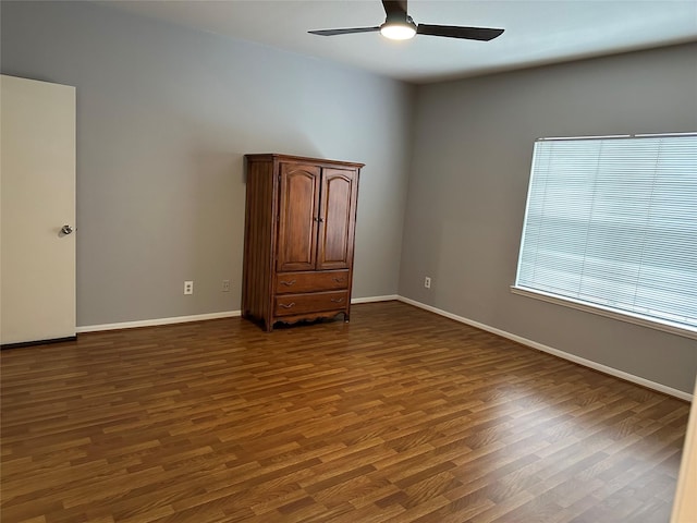 unfurnished room with ceiling fan and dark hardwood / wood-style flooring