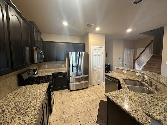 kitchen featuring backsplash, sink, light stone countertops, light tile patterned flooring, and stainless steel appliances