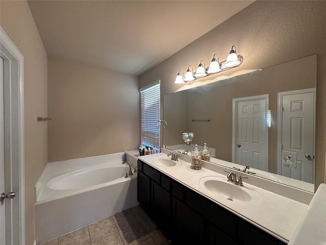 bathroom with double vanity, a bath, tile patterned floors, and a sink