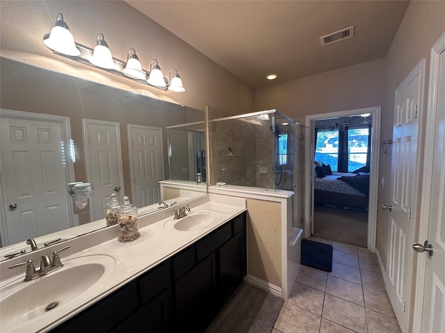 bathroom with double vanity, a shower stall, visible vents, and a sink
