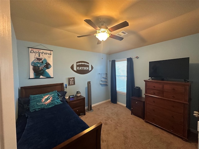 bedroom featuring baseboards, visible vents, a ceiling fan, and light colored carpet