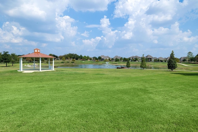 view of property's community featuring a gazebo, a water view, and a lawn