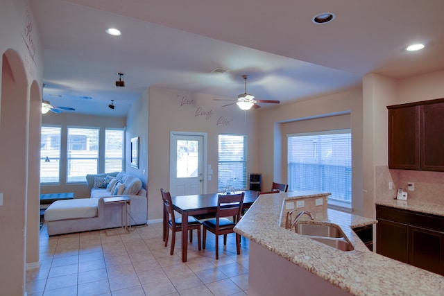 dining room featuring light tile patterned floors, ceiling fan, and sink