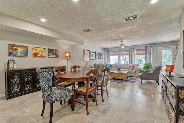 dining space featuring a textured ceiling, plenty of natural light, ceiling fan, and light tile patterned floors