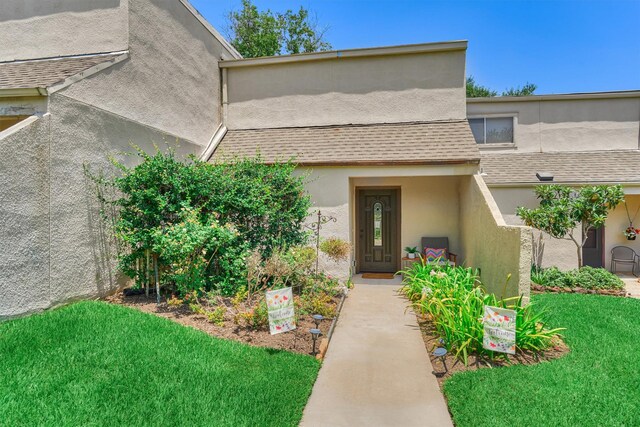 property entrance featuring a lawn