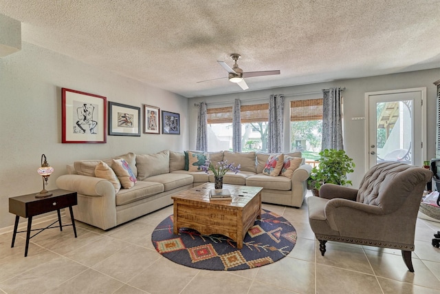 living room with a textured ceiling, a wealth of natural light, ceiling fan, and light tile patterned floors