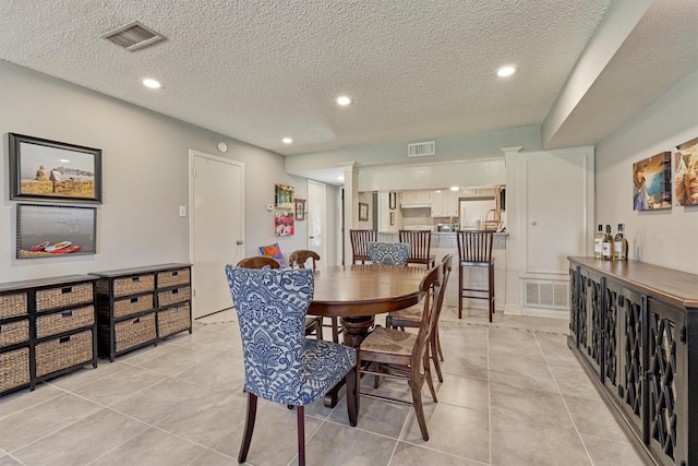 tiled dining area with a textured ceiling