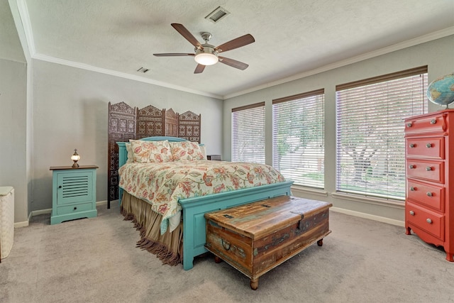 carpeted bedroom featuring a textured ceiling, ornamental molding, and ceiling fan