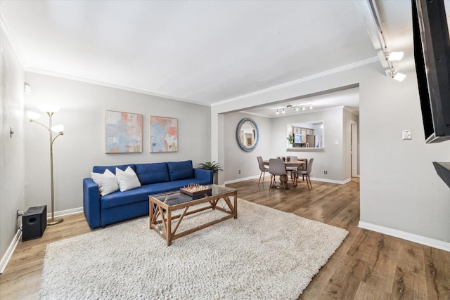 living room featuring hardwood / wood-style floors, track lighting, and crown molding