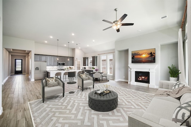 living room with ceiling fan and light hardwood / wood-style flooring