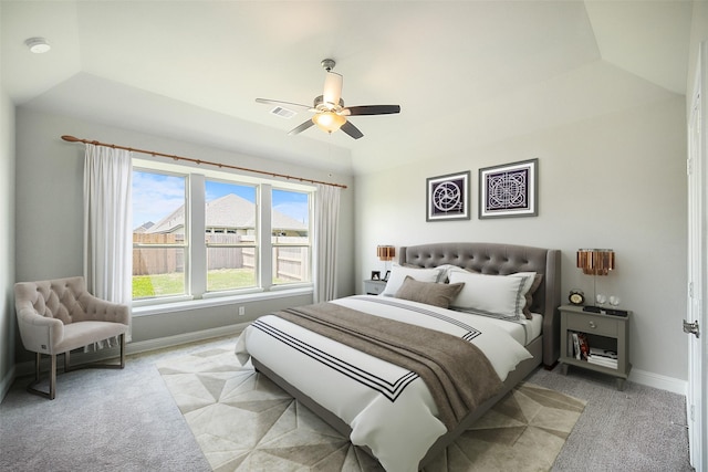 carpeted bedroom featuring ceiling fan, a raised ceiling, and lofted ceiling