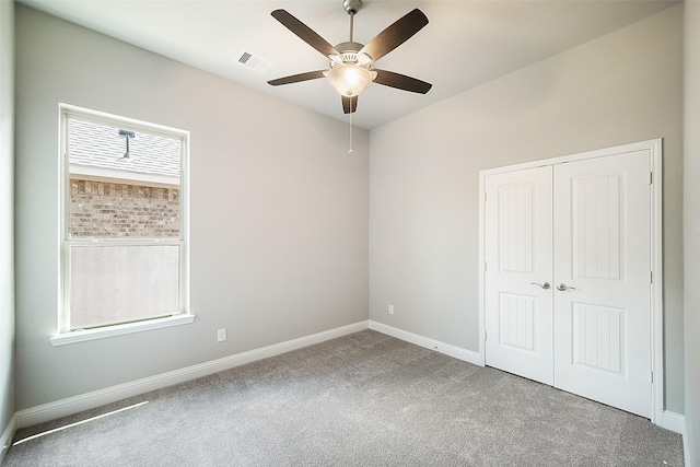 unfurnished bedroom with carpet flooring, ceiling fan, and a closet