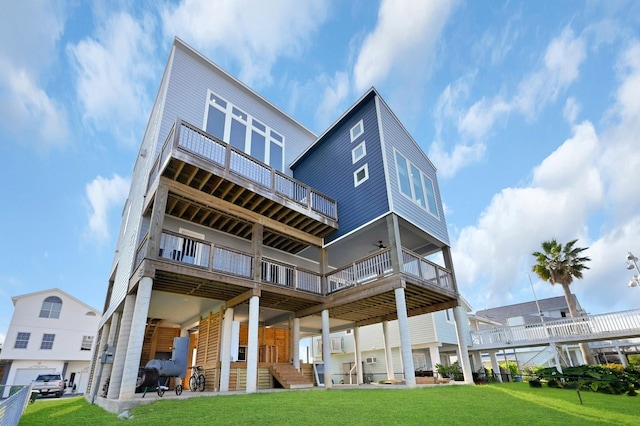 rear view of property with ceiling fan and a yard