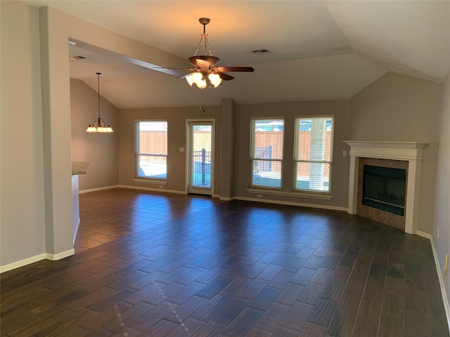 unfurnished living room featuring ceiling fan with notable chandelier, vaulted ceiling, and a tiled fireplace