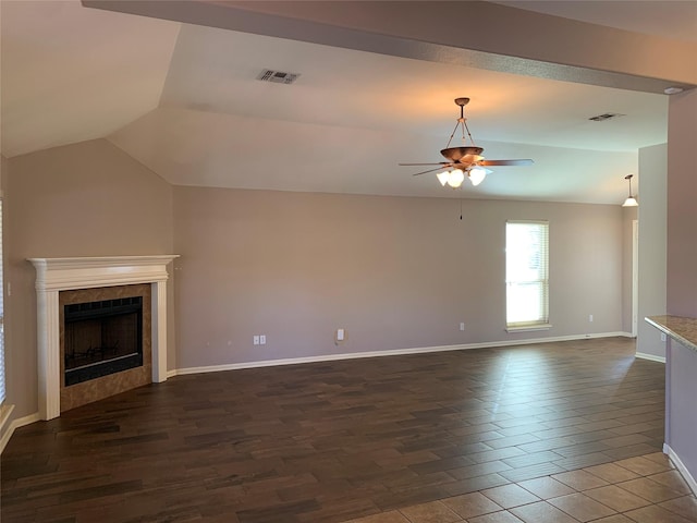 unfurnished living room featuring ceiling fan, a tile fireplace, and vaulted ceiling