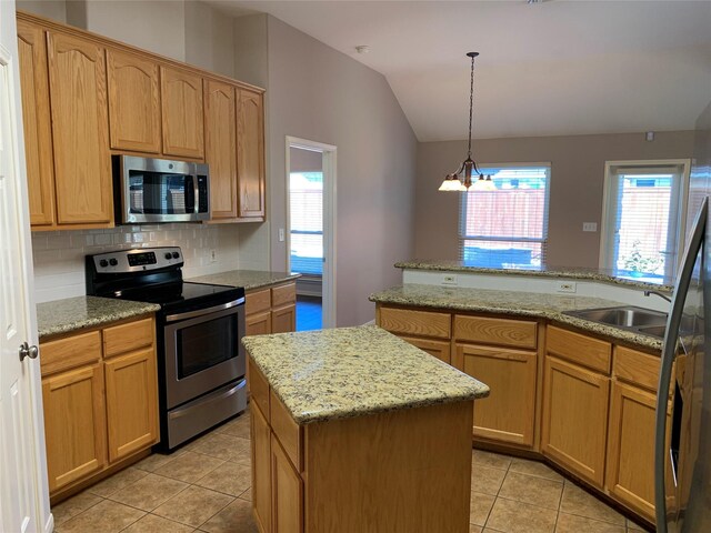 kitchen featuring a center island, an inviting chandelier, appliances with stainless steel finishes, tasteful backsplash, and decorative light fixtures