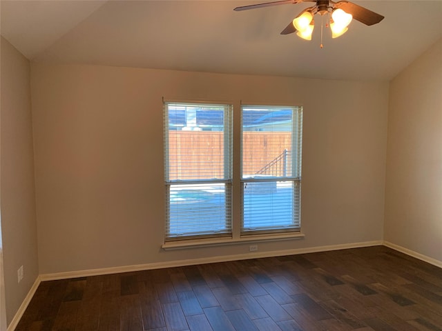 spare room with dark hardwood / wood-style floors, vaulted ceiling, and ceiling fan