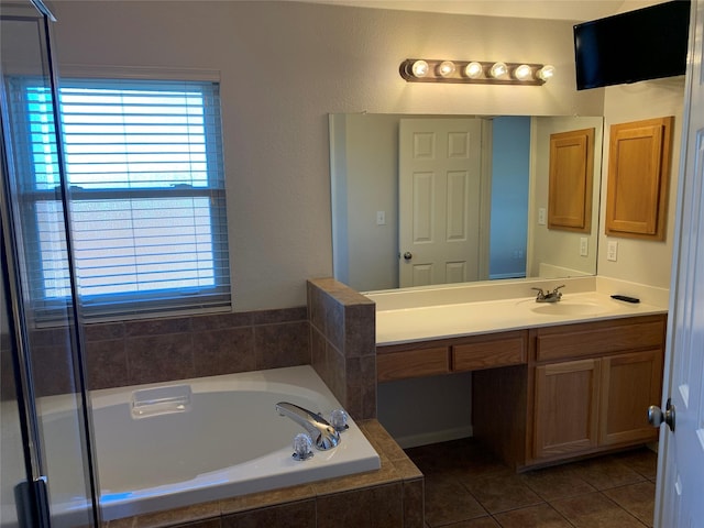 bathroom featuring tile patterned flooring, a relaxing tiled tub, and vanity