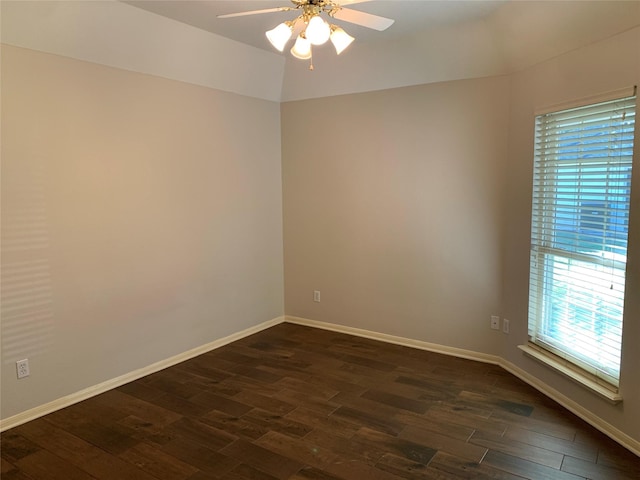 empty room with dark hardwood / wood-style floors, vaulted ceiling, plenty of natural light, and ceiling fan