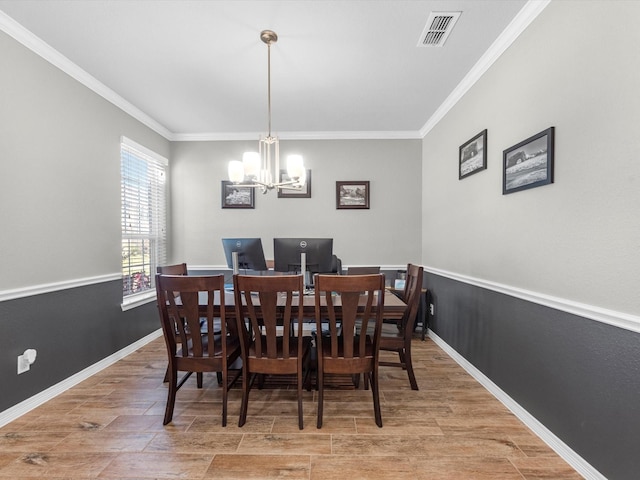 dining area with ornamental molding and an inviting chandelier