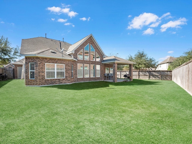 rear view of property with a yard and a patio