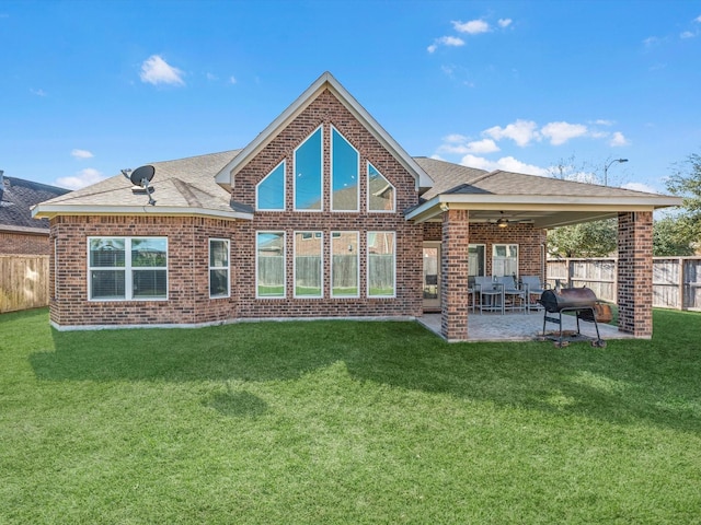 rear view of property with a lawn, ceiling fan, and a patio area