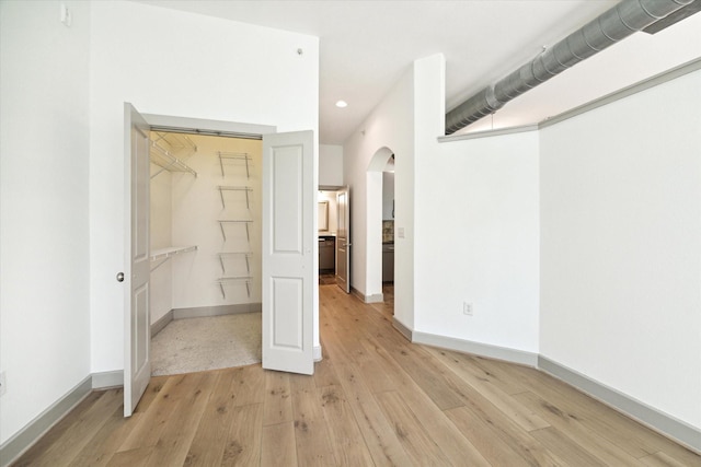 unfurnished bedroom featuring a closet and light hardwood / wood-style flooring