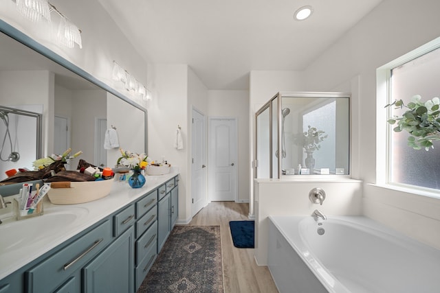 bathroom with hardwood / wood-style flooring, vanity, and separate shower and tub