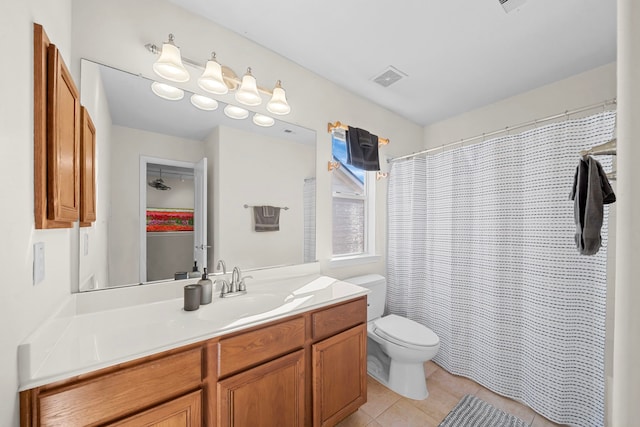 bathroom featuring tile patterned floors, vanity, toilet, and walk in shower