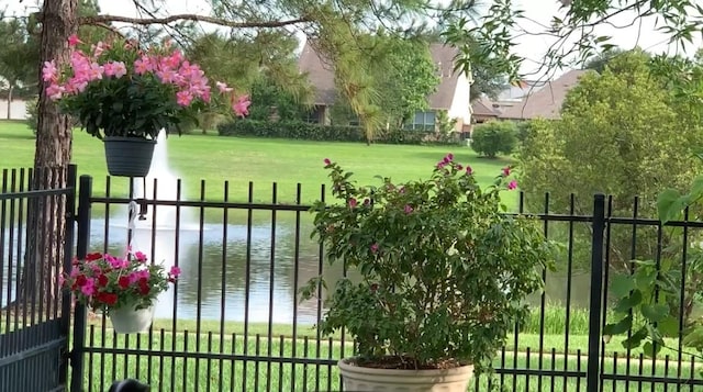 view of gate featuring a water view and a lawn