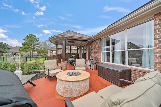 view of patio / terrace featuring ceiling fan and an outdoor living space with a fire pit